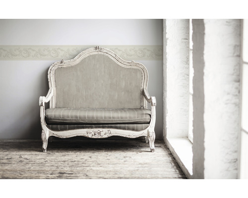 Sofa décoratif avec bordure florale au mur pour une ambiance élégante dans la pièce.