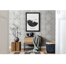 Dekoratives Wohnzimmer mit gemusterter Tapete, Holzmöbeln und einem gerahmten Bild.