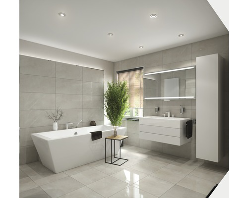 Salle de bain lumineuse avec baignoire îlot, meuble-lavabo et armoire de toilette