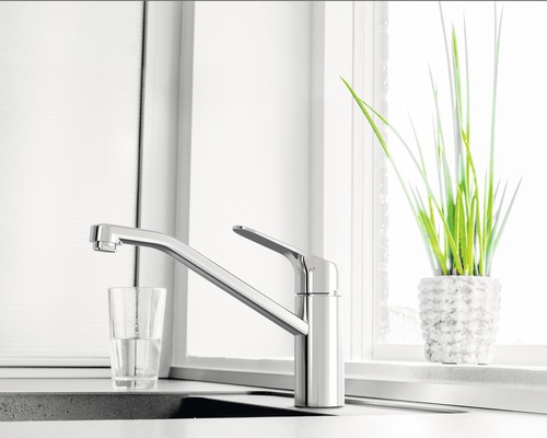 Scène de cuisine avec robinet d''évier, verre d''eau et plante en pot
