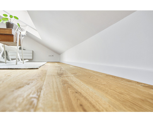 Dachgeschosszimmer mit Holzboden, weißen Wänden und Möbeln