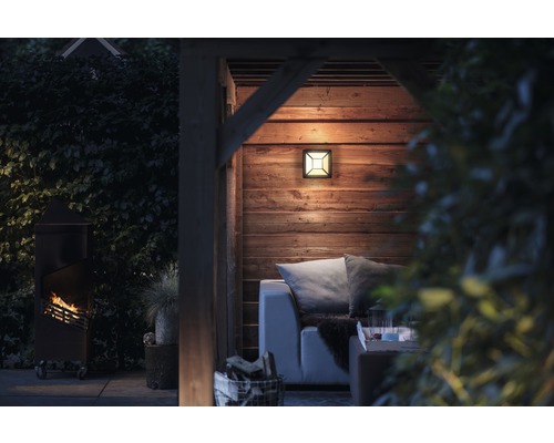 Espace extérieur éclairé avec lampe, poêle à bois et coin salon