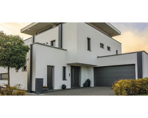 Modernes Haus mit Garage, Haustür und gepflasterter Auffahrt