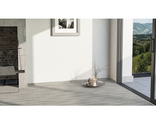 Pièce claire avec sol carrelé, porte de terrasse et barbecue en maçonnerie