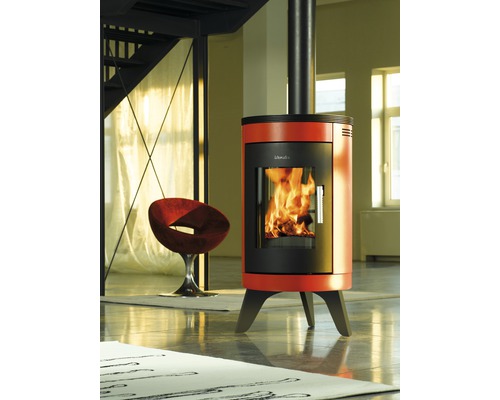 Freistehender Kaminofen mit Rohr und Glasfenster in einem hellen Raum.