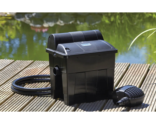 Filtre de bassin avec pompe et tuyau sur un ponton en bois devant un bassin