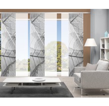 Salon avec rideaux coulissants à motifs de feuilles, fauteuil, table et étagère