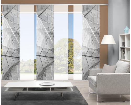 Salon avec rideaux coulissants à motifs de feuilles, fauteuil, table et étagère