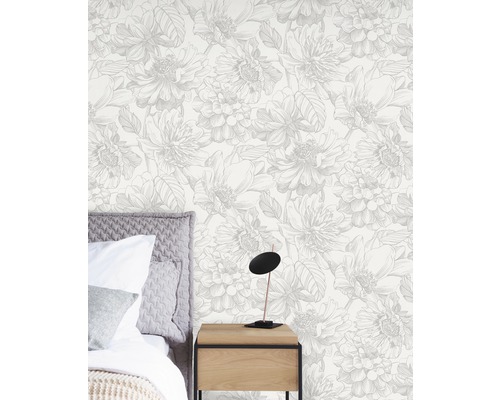 Chambre avec papier peint floral, lit et lampe de chevet