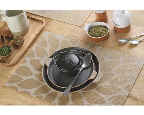 Tischdekoration mit Platzsets und Geschirr auf einem Holztisch