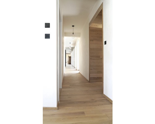 Flur mit Holzboden, weißen Wänden und minimalistischen Pendelleuchten