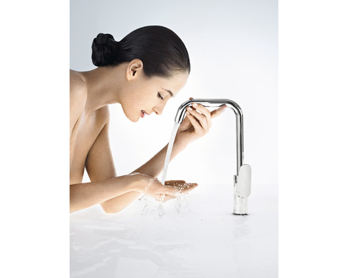 Frau benutzt eine Armatur mit Wasserdurchlauf