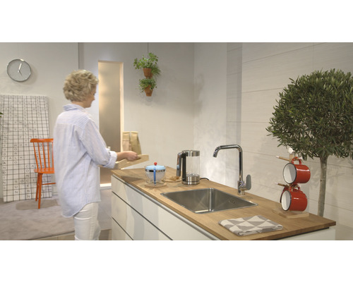 Cuisine moderne avec évier, robinet et ustensiles de cuisine sur un plan de travail en bois