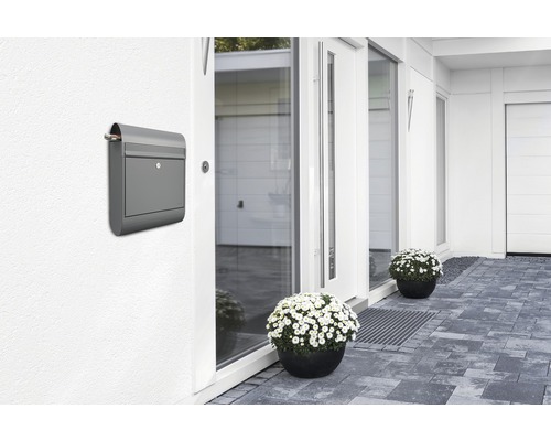 Boîte aux lettres grise sur un mur de maison près de l''entrée