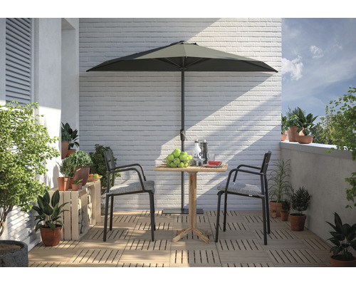 Balkonszene mit Gartentisch, Sonnenschirm, Stühlen und Pflanzen für eine helle, freundliche Atmosphäre.