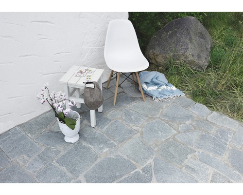 Aussenbereich mit Natursteinpflaster, Stuhl, Tisch und Dekoration