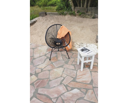 Szene mit Outdoor-Sitzgelegenheit, bestehend aus einem Sessel und einem Beistelltisch auf einer Terrasse