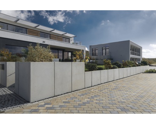 Photo extérieure de deux maisons modernes avec mur en béton et pavés