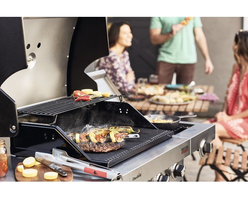 Gril en acier inoxydable avec des aliments grillés et des personnes en arrière-plan