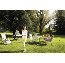 Scène de jardin avec barbecue, table de jardin et chaises de jardin sous les arbres