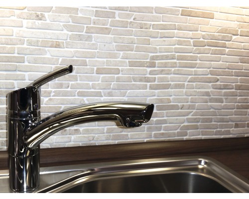 Küchenspüle mit Armatur vor einer Ziegelwand