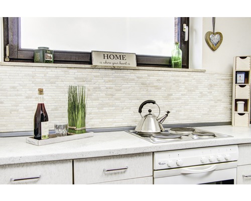 Küchenszene mit Kochfeld, Teekessel, Dekorationen und Küchenutensilien auf einer Arbeitsplatte.