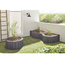 Terrasse avec bacs à plantes et graminées ornementales sur gazon synthétique