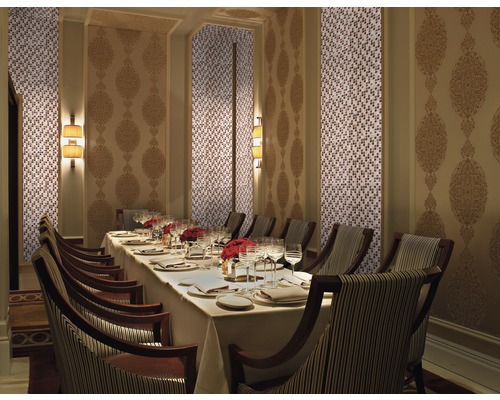 Salle à manger élégante avec mur en mosaïque, panneau mural décoré, table dressée et chaises