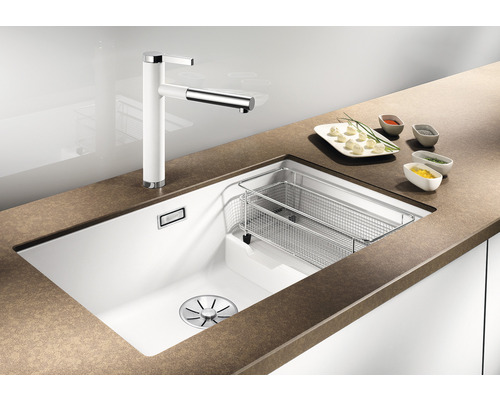 Küchenspüle mit Abtropfkorb und Armatur auf einer Küchentheke.