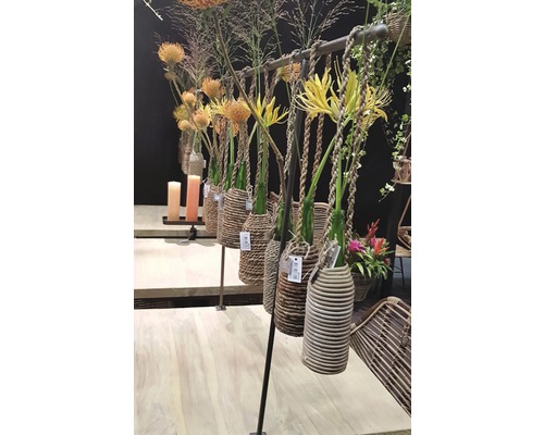 Arrangements floraux décoratifs avec vases dans des paniers tressés sur un support
