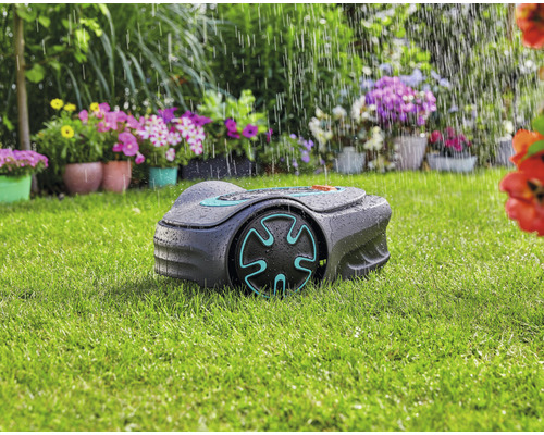 Robot de tonte en marche sous la pluie dans le jardin.