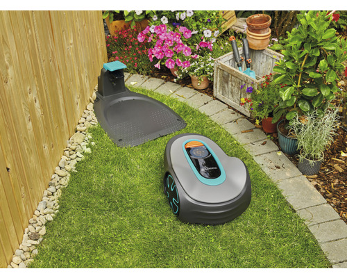 Robot tondeuse Gardena avec station de charge sur une pelouse dans un jardin