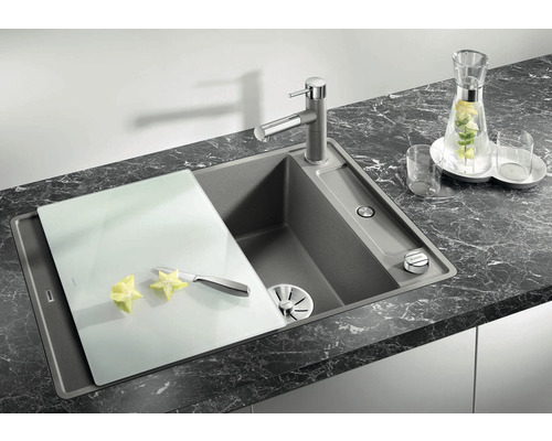 Küchenspüle mit Schneidebrett und Armatur auf dunkler Arbeitsplatte