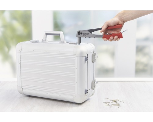 Main rivete une valise en aluminium avec une pince à riveter