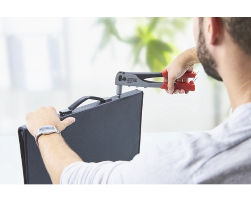 Une personne fixe une pièce à l''aide d''une pince à riveter de la marque Novus.
