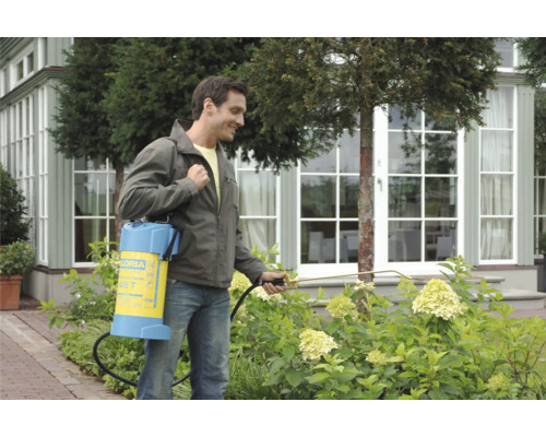 Ein Mann verwendet ein Gloria Drucksprühgerät im Garten, um Pflanzen zu behandeln.