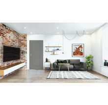 Salon avec mur en briques, télévision, porte, canapé et tapis.