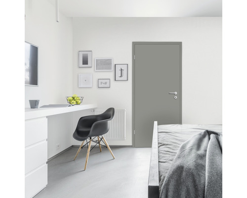 Modernes Zimmer mit Tür, Bett, Schreibtisch und Stuhl.