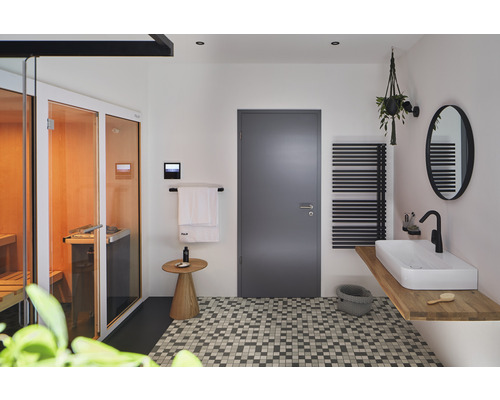 Helles Badezimmer mit Sauna, Waschtisch, Heizkörper und Mosaikfliesen