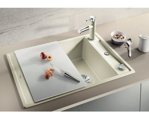 Évier de cuisine avec planche à découper, robinet, fruits et bol de muesli