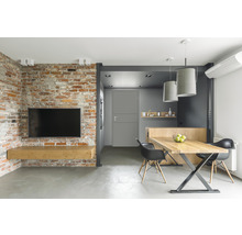 Wohnzimmer mit Ziegelwand, Fernseher, Holztisch und Stühlen.