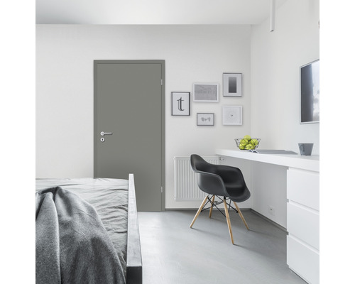 Graue Innentür in einem hellen Schlafzimmer mit Bett, Schreibtisch und Stuhl