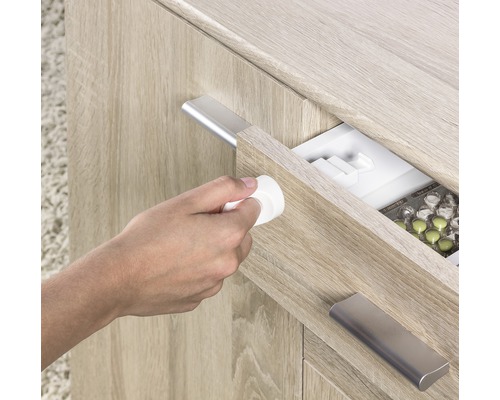 Une personne ouvre un tiroir contenant des médicaments avec un verrou de sécurité enfant.