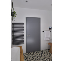 Helles Badezimmer mit Heizkörper, Tür, Handtuch und Mosaikfliesen
