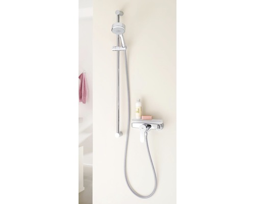 Duscharmatur mit Brausestange und Ablage für Badprodukte an der Wand montiert.