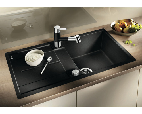 Évier noir avec égouttoir et robinet sur un plan de travail