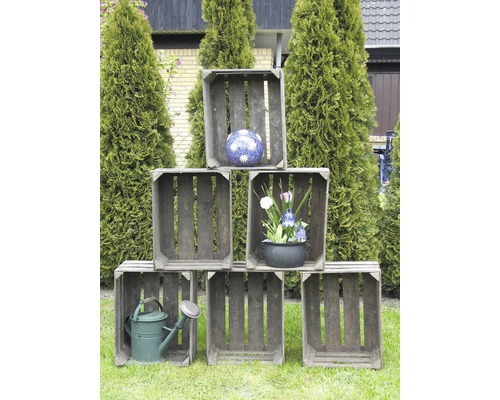 Dekorative Holzsteigen mit Blumenschmuck und Giesskanne im Garten