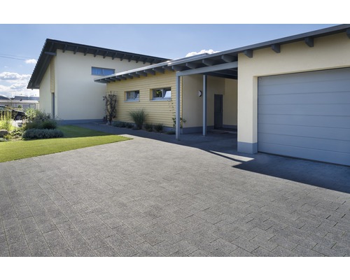 Außenaufnahme eines Hauses mit gepflasterter Einfahrt, Garage und Carport