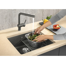 Spüle mit Armatur und Gemüse wird gewaschen