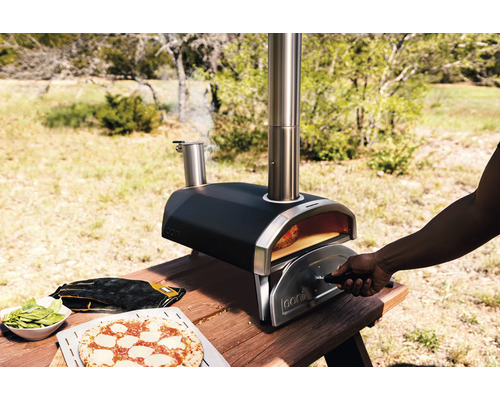 Four à pizza Ooni sur une table en bois avec pizza et ingrédients